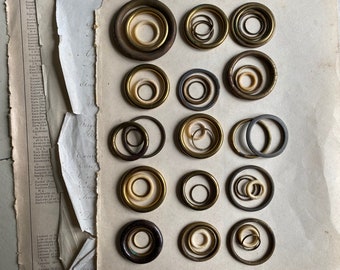 A varied selection of vintage French curtain rings, brass, bronze, bone