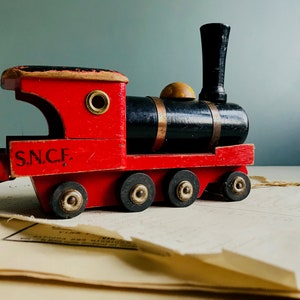 A vintage French wooden toy train, red wooden train, SNCF train, pull along train