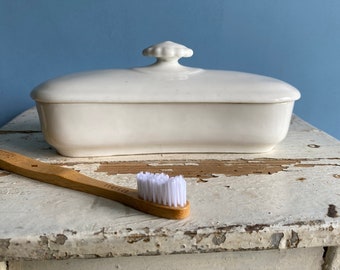 A vintage French white porcelain toothbrush dish