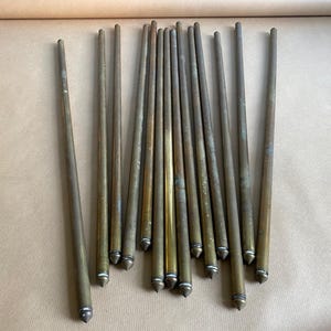 以下が含まれることがあります： 先のとがった端を持つ金色の金属棒が18本あります。棒は扇形に配置されており、すべて同じ長さです。