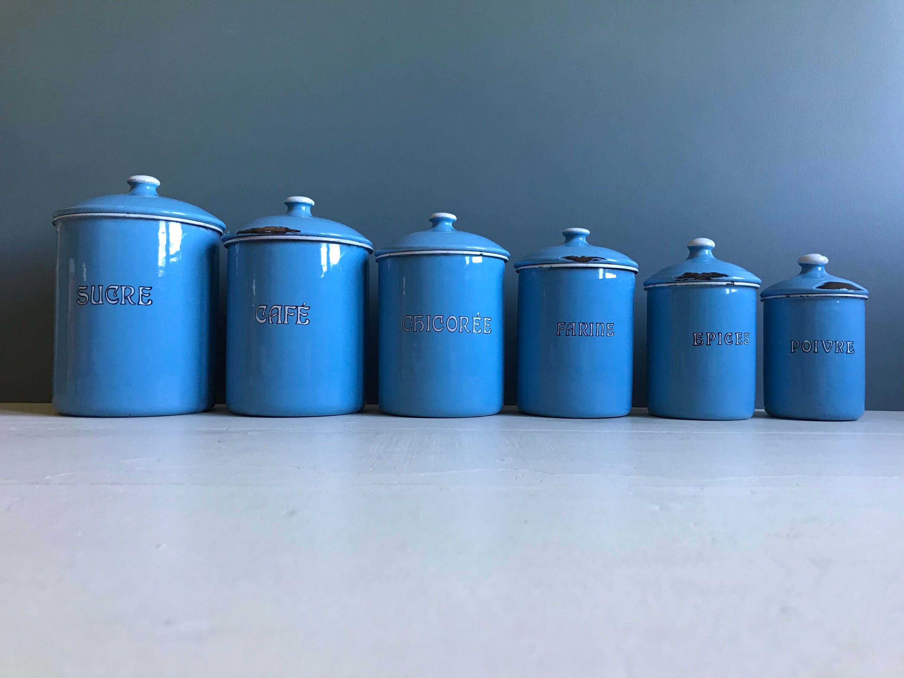 A vintage Belgian chippy enamel canister set, blue enamel storage tins