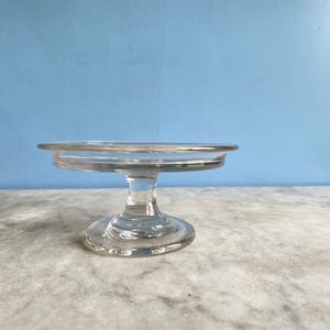 A small vintage French clear glass pedestal plate