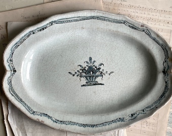 An antique French faience plate, Rouen faience, cul noir, 18th century, stapled plate, visibly mended, white, blue