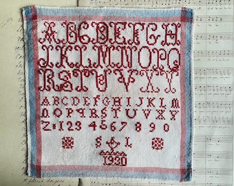 A vintage French hand embroidered alphabet sampler, 1930, red cross stitch sampler