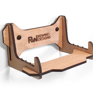 Peut inclure: Support mural en bois pour console de jeux vidéo, avec le logo "RW Rewind Designs" gravé sur le devant. Le support dispose d'une étagère pour les manettes ou autres accessoires.
