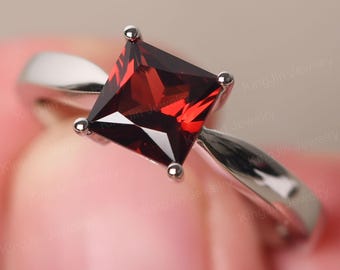 Anillo solitario de granate sencillo en plata de ley con corte princesa y piedra de nacimiento de enero.