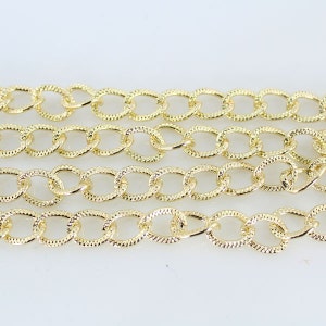 May include: A gold chain with a textured oval link design.