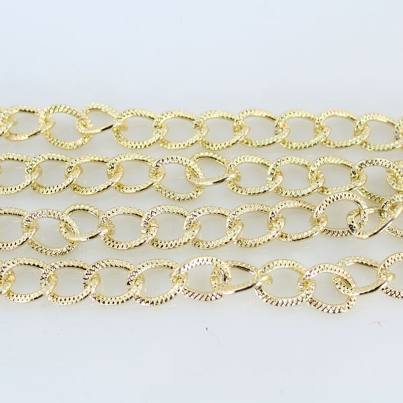 May include: A gold chain with a textured oval link design.