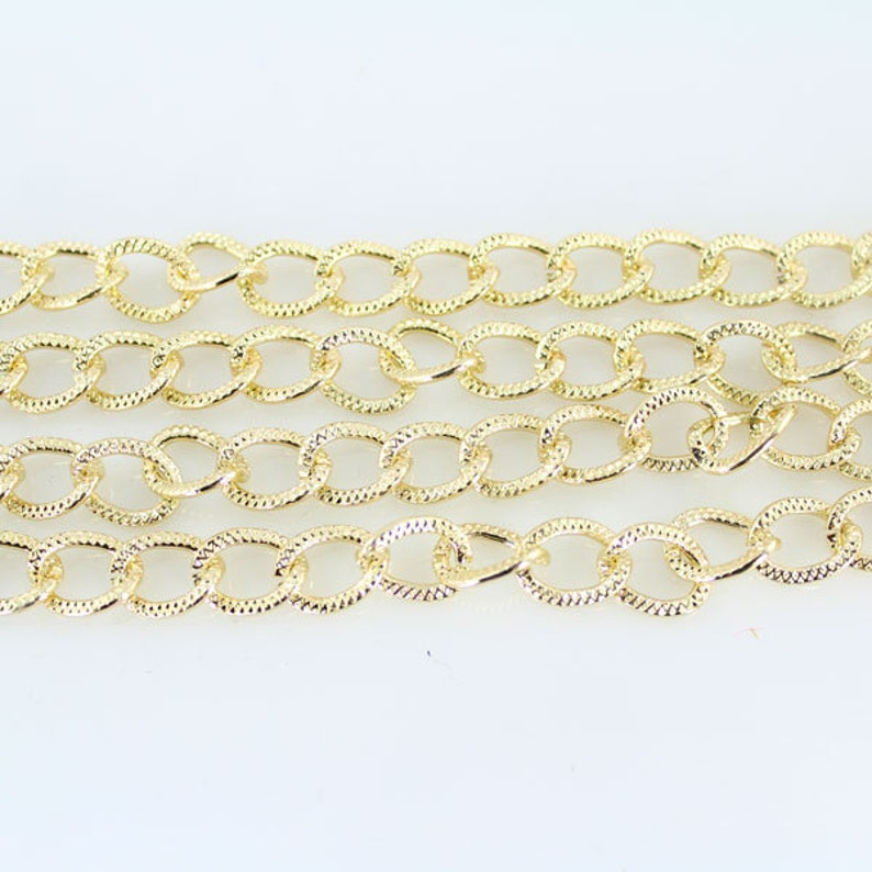 May include: Gold chain with a textured oval link design.