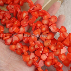 May include: A strand of orange coral beads, each bead is a unique, irregular shape with a smooth, polished finish. The beads are strung together to create a necklace or bracelet.
