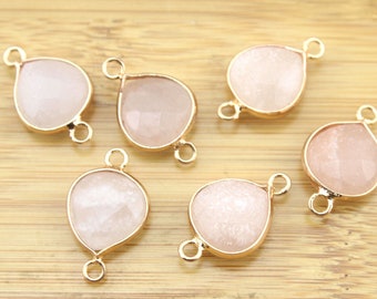 May include: Six gold-tone teardrop-shaped charms with a white, sparkly finish. Each charm has two jump rings for attaching to jewellery.