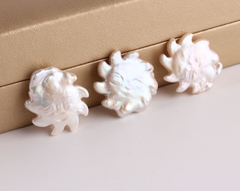 May include: Three white pearl shell sun shapes with a textured surface. The shells are arranged in a row on a gold surface.