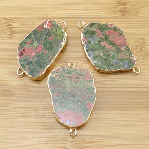 May include: Three green and pink gemstone pendants with gold-toned metal accents. The pendants are irregularly shaped and have a natural, raw look.