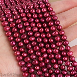 Puede incluir: Una hebra de perlas de agua dulce de color rojo intenso. Las perlas son redondas y lisas, con un alto brillo. Están enhebradas en un hilo transparente.