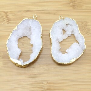 Puede incluir: Dos rebanadas de &aacute;gata blanca con bordes chapados en oro. Las rebanadas de &aacute;gata tienen una forma natural irregular con un agujero en el centro. Las rebanadas son perfectas para la elaboraci&oacute;n de joyas o manualidades.