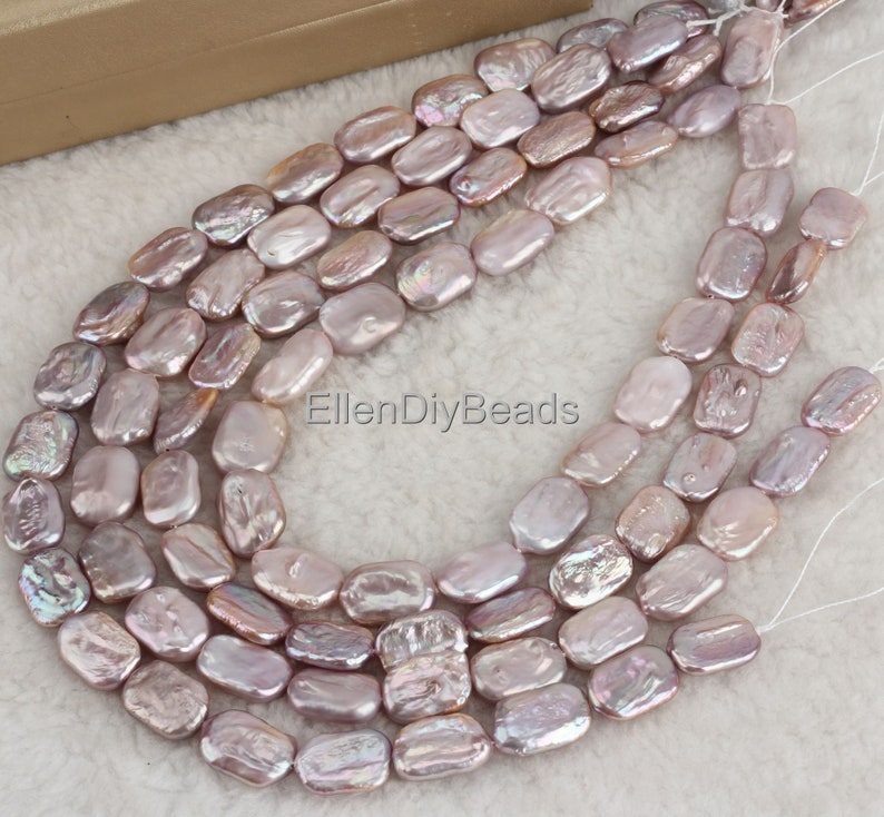 May include: A strand of pale lavender baroque freshwater pearl beads. The pearls are oval shaped and have a slightly irregular surface. The beads are strung on a white thread and are ready to be used for jewelry making.