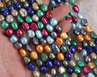 May include: A strand of colorful freshwater pearls, featuring a variety of shapes and sizes. The pearls are strung on a clear thread and are ready to be used for jewelry making.