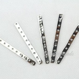 Peut inclure: Cinq barres de connexion en métal argenté avec des trous sur toute leur longueur. Ces barres sont utilisées pour la fabrication de bijoux et l'artisanat.