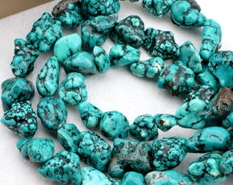 May include: A strand of turquoise gemstone beads. The beads are a vibrant turquoise color with dark brown and black matrix patterns. The irregular, nugget-like shapes vary in size and texture, creating a natural, organic look. Ideal for jewelry making.