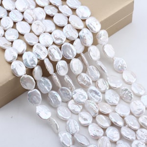 Può includere: Una collana di perle d'acqua dolce bianche. Le perle sono rotonde e hanno una finitura liscia e iridescente. Sono infilate su un filo bianco e sono perfette per realizzare gioielli.