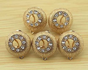May include: Five gold-tone round earrings with clear rhinestone accents. Each earring has a circular design with a smaller circle in the centre.