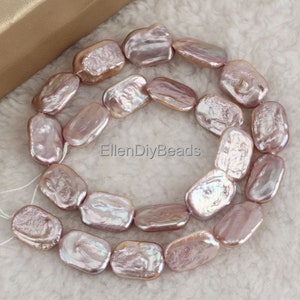 May include: A strand of iridescent pink freshwater pearls, each pearl is a unique, irregular oval shape. The pearls are strung on a white thread and are ready to be used for jewelry making.