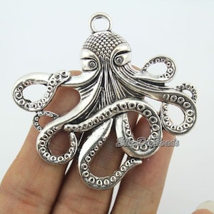 Puede incluir: Encanto de pulpo plateado con tentáculos y ojos detallados. El encanto tiene un bucle en la parte superior para sujetarlo a joyas u otras manualidades.