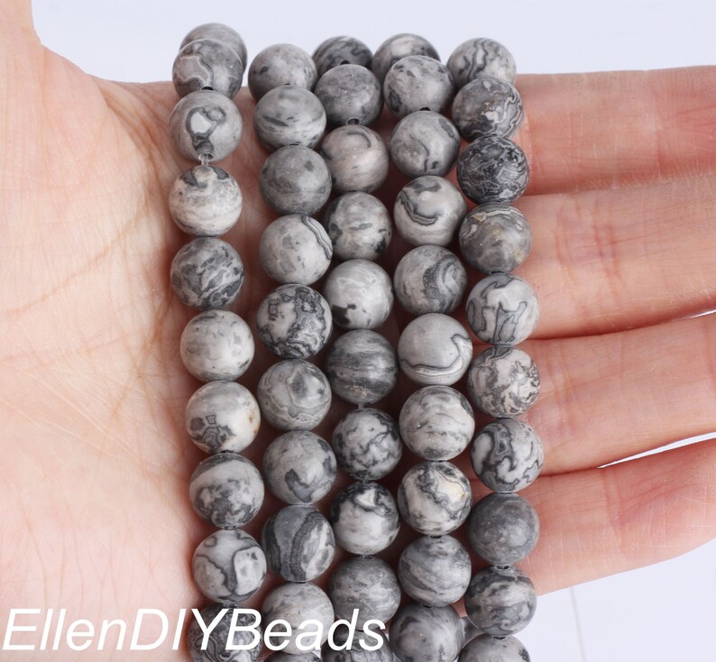 May include: A strand of gray and black marbled round beads. The beads are approximately 8mm in diameter and have a smooth, polished finish.