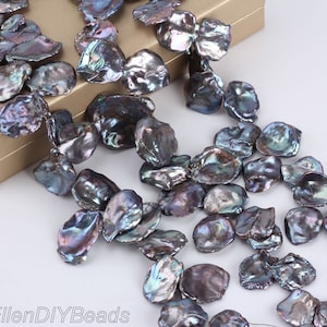 May include: A strand of iridescent black freshwater pearls, each pearl is a unique, irregular shape. The pearls are strung on a thin wire and are ready to be used for jewelry making.