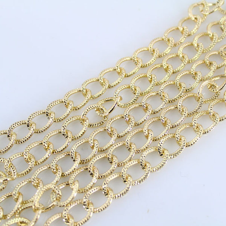 May include: Gold chain with a textured oval link design.