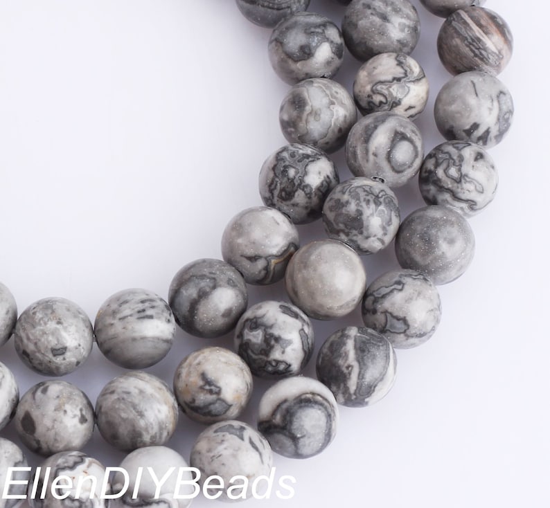 May include: A strand of gray and black marbled round beads. The beads are approximately 10mm in diameter.
