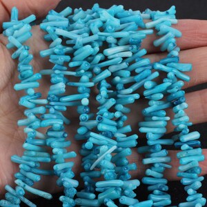 Puede incluir: Una hebra de cuentas de coral azul turquesa. Las cuentas son largas y delgadas, con una forma natural irregular. Son perfectas para hacer joyas u otras manualidades.