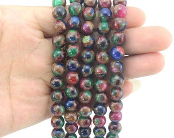 Peut inclure: Un brin de perles rondes multicolores avec une finition dorée métallisée. Les perles sont en verre et ont un aspect moucheté. Les perles sont enfilées sur un cordon élastique transparent.