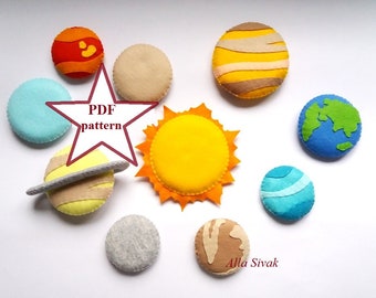 May include: Felt craft pattern for making a solar system with the sun, planets, and a star. The pattern is available as a PDF download. The planets are in different colors, including blue, green, yellow, orange, and brown.