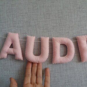 May include: Pink felt letter banner spelling out the name "AUDREY".