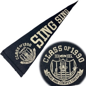 May include: Black and gold pennant with the text "SING SING" and the words "Class of 1990" with a graphic of a person in a prison cell with the text "Bars and Stripes Forever".