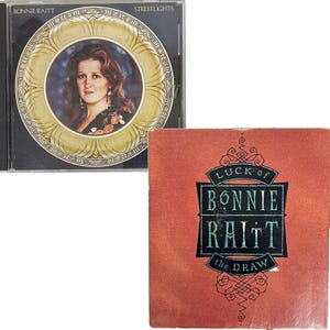 May include: Two Bonnie Raitt music albums are displayed. The CD case for "Streetlights" features a portrait of Raitt in a gold-toned frame. The album cover for "Luck of the Draw" is a reddish-orange with black and teal text and decorative elements.
