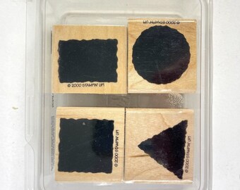 May include: A set of four wooden stamps with black ink pads. The stamps feature a square, circle, rectangle, and triangle.