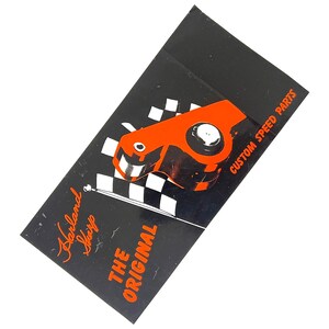 Może przedstawiać: Pomarańczowo-czarna niestandardowa część do tuningu, z tekstem "Custom Speed Parts" i "The Original". Część znajduje się na czarnym tle z wzorem szachownicy. Widoczny jest również tekst "Harland Sharp".