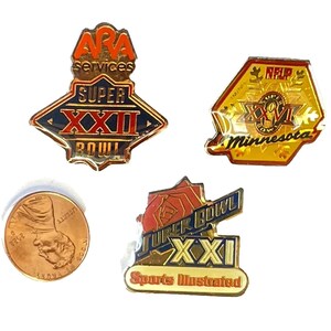May include: Three Super Bowl XXXI commemorative pins. The first pin is gold with red and blue accents and features the text "ARA services Super Bowl XXXI". The second pin is gold with red and black accents and features the text "NFL/NFUP Minnesota". The third pin is gold with red and blue accents and features the text "Super Bowl XXXI Sports Illustrated".