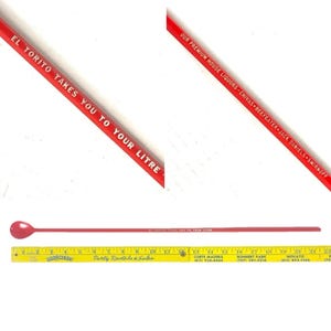 Op de afbeelding: Een rode barlepel met een afgerond lepeluiteinde. De tekst "EL TORITO TAKES YOU TO YOUR LITRE" staat op de lepel. De lepel is ongeveer 30 cm lang.