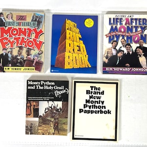 May include: A collection of Monty Python books, including "The First 200 Years of Monty Python," "Monty Python's Big Red Book," and "Before and Life After Monty." The books feature colorful covers with text and images.