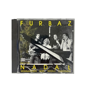 May include: A CD case featuring the band Furbaz. The cover has a black and white photo of the band members with the word "NADAL" in yellow letters. The CD case also has the words "WEIHNACHTEN - NOEL - NATALE - CHRISTMAS".