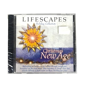 以下が含まれることがあります： 「Lifescapes Holiday Collection: Christmas New Age」のアルバムが収録された、未開封のCDケース。カバーには金色のスターバーストのデザインとアルバムタイトルが表示されています。テキストには「常緑樹を転がる山の空気のように爽やかです。」と書かれています。