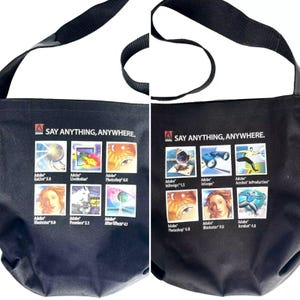 May include: Black canvas tote bag with the Adobe logo and the text "Say Anything, Anywhere." The bag features a grid of nine images representing different Adobe products, including Photoshop, Illustrator, Acrobat, and InDesign.