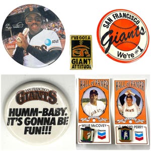 May include: A collection of San Francisco Giants memorabilia, including pins, buttons, and cards. The items feature the team's logo, players, and slogans like "Humm-Baby. It's Gonna Be Fun!!!" and "We're #1".