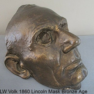 May include: A bronze cast of Abraham Lincoln's face, created by LW Volk in 1860. The mask is a detailed representation of Lincoln's features, including his prominent nose and deep-set eyes.
