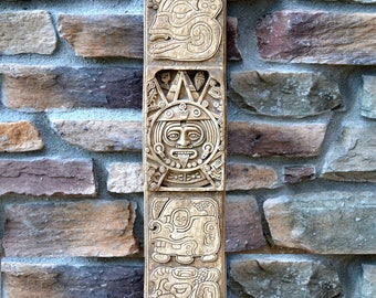 May include: A carved wooden totem pole with a sun face and other figures. The totem pole is 28 inches tall and is made of aged stone. "NEO-MFG Totem Cal 28" Aged Stone