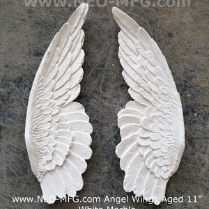 May include: A pair of white marble angel wings, each measuring 11 inches in length. The wings have a detailed, textured design and are aged for a vintage look.