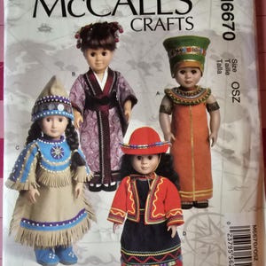 May include: McCall's Crafts sewing pattern featuring four dolls in various historical and cultural costumes. The dolls are dressed in outfits representing different cultures, including a Native American, a Japanese kimono, and an Egyptian pharaoh.